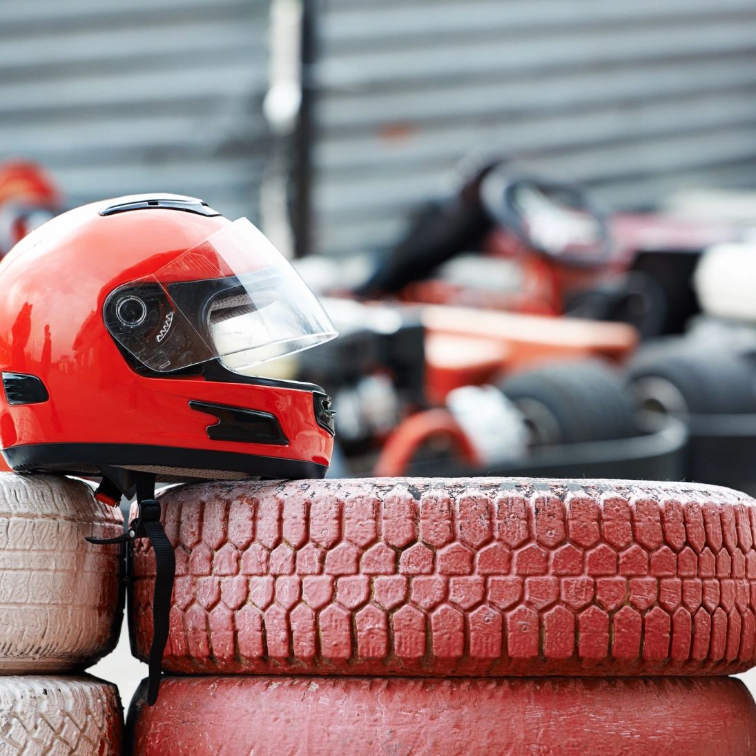 Racing helmet resting on stacked tyres
